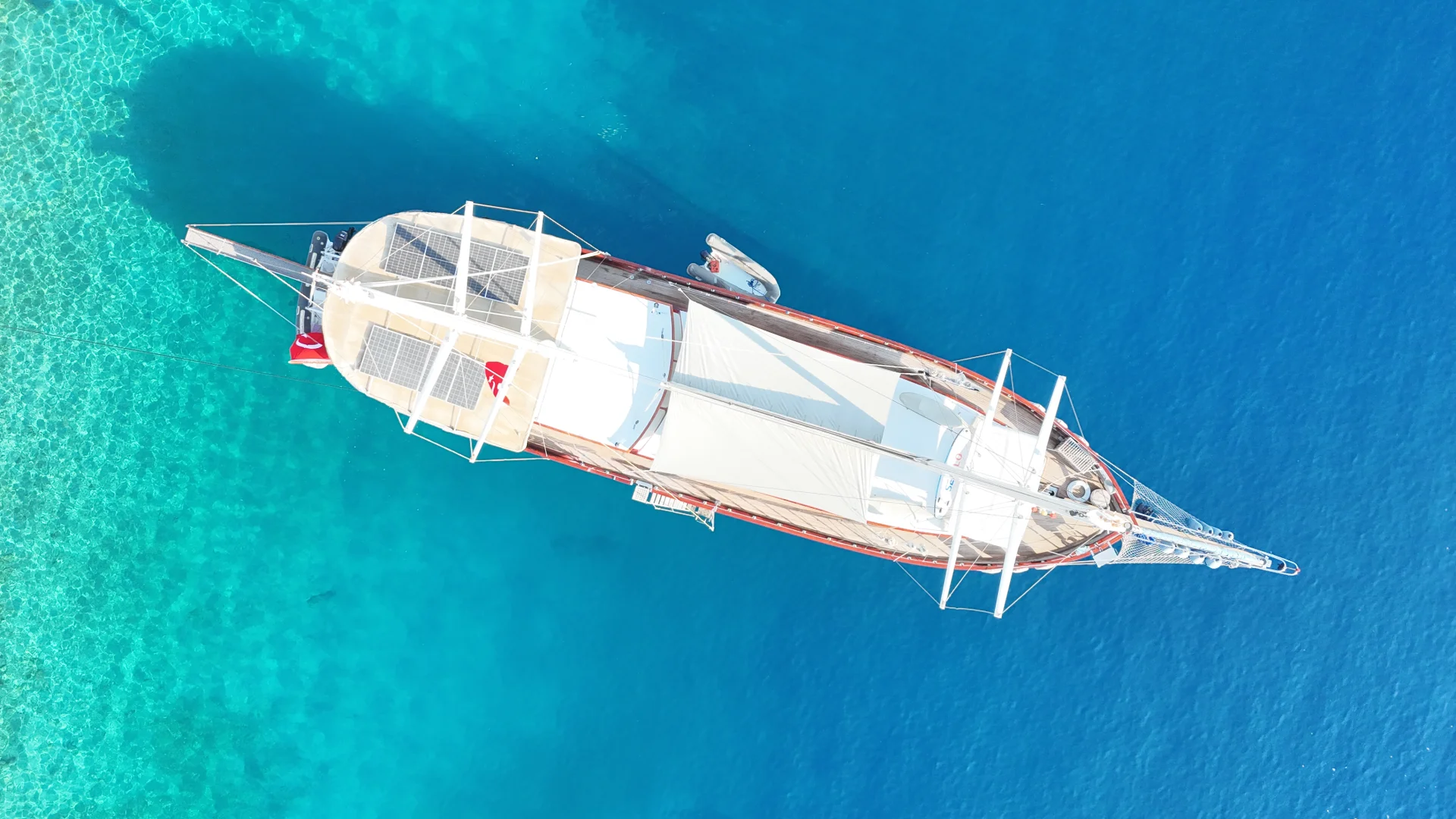 Aerial view of traditional gulet sailing in turquoise water