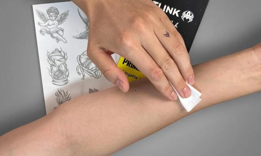 Cleaning skin with a wipe before applying a temporary tattoo.