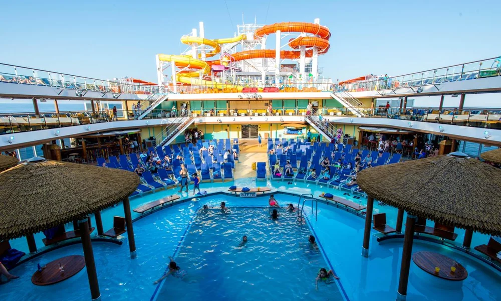 Families enjoying a cruise ship pool and water slides