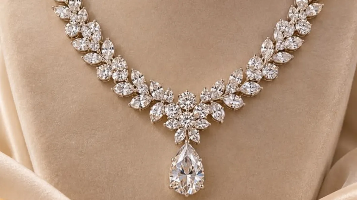 luxury diamond necklaces showcased in a close-up photo of an elegant leaf-patterned marquise diamond necklace featuring a teardrop pear-cut pendant displayed on beige velvet.