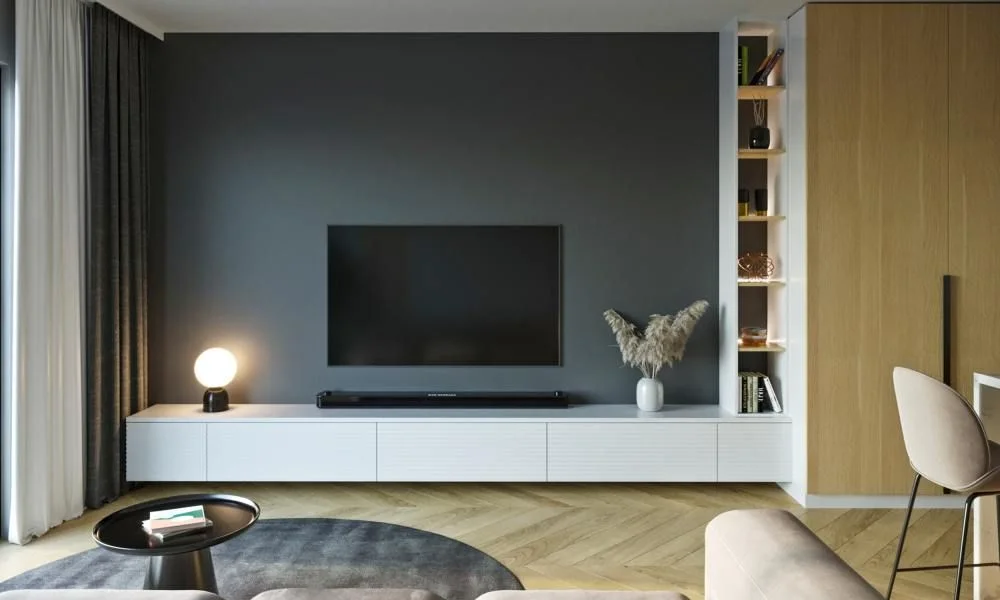 Modern minimalist living room with a wall-mounted TV, floating white media console, warm wood cabinetry, soft lighting, and a neutral rug, creating a calm, inviting mood.