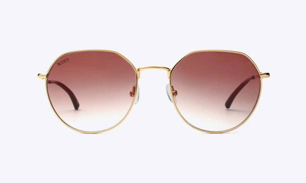 Gold-framed round sunglasses with rose-to-clear gradient lenses and dark temples, shown against a plain white background; stylish, polished product presentation.