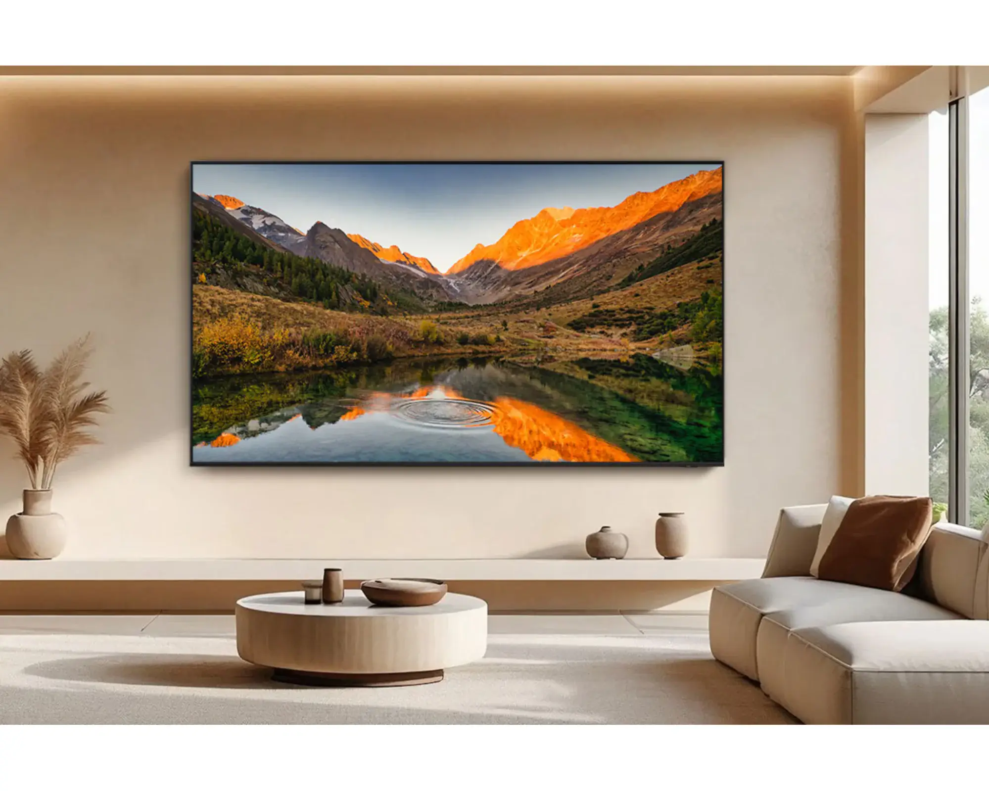 A minimalist living room features a large framed mountain-lake landscape glowing orange at sunset, bringing a peaceful, warm focal point to the neutral space.