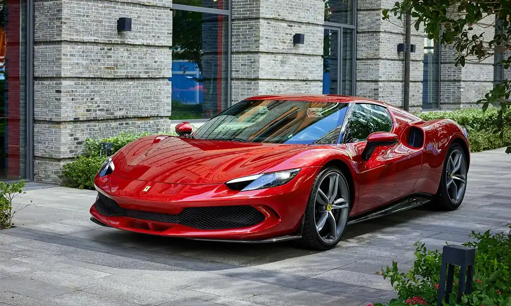 Vibrant red Ferrari 296 GTB hybrid sports car parked on a paved courtyard