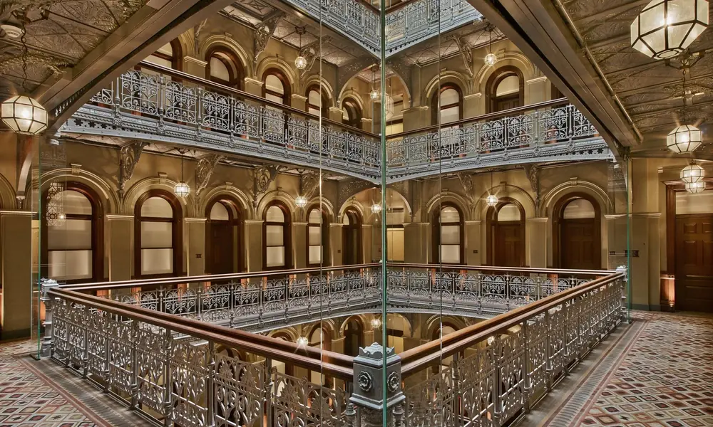 Historic hotel atrium with ornate balconies and a glass skylight.