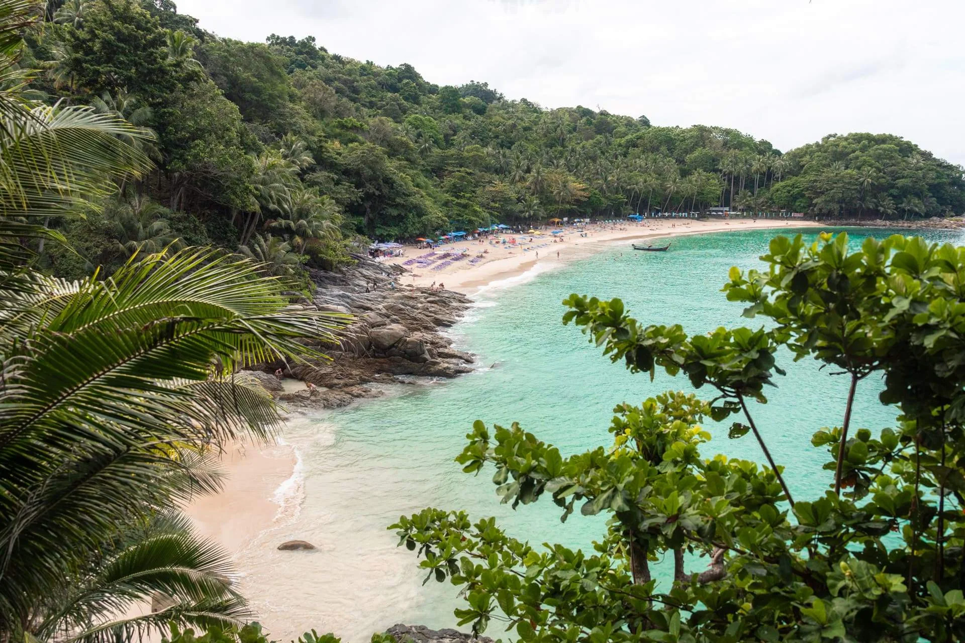 Tropical sandy cove surrounded by green jungle hills