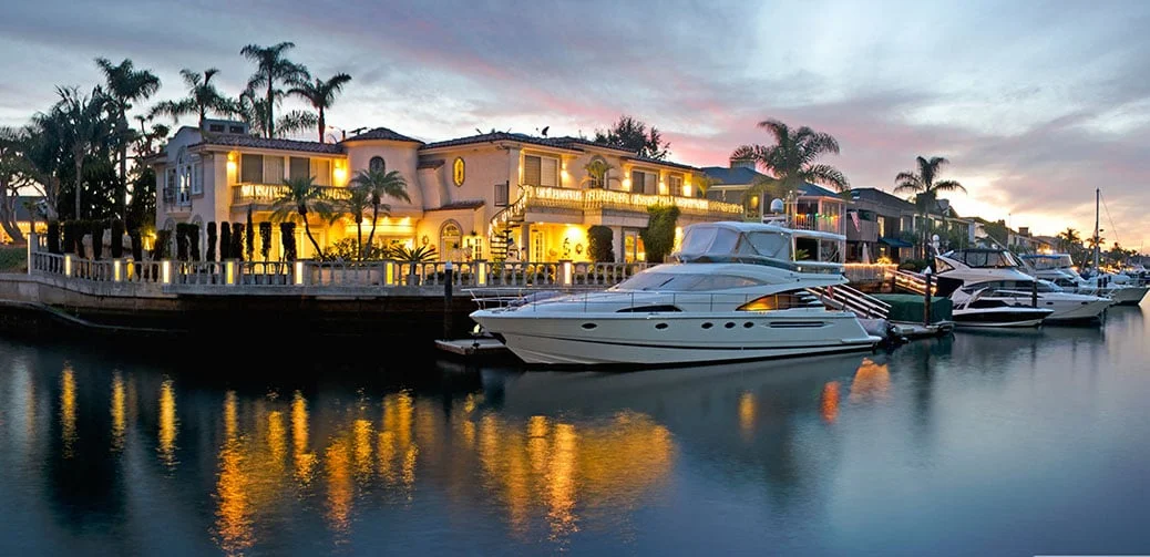 Yachts docked at a coastal marina during evening light