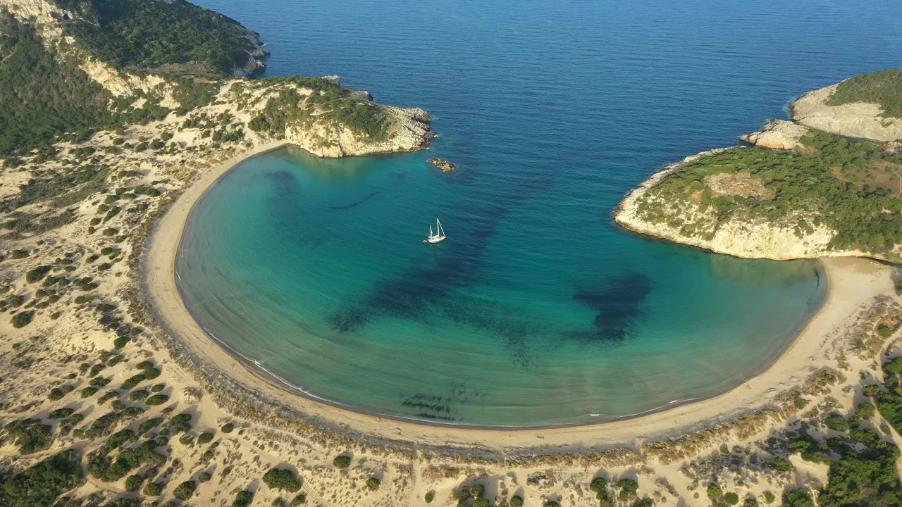 Curved sandy bay with calm turquoise waters
