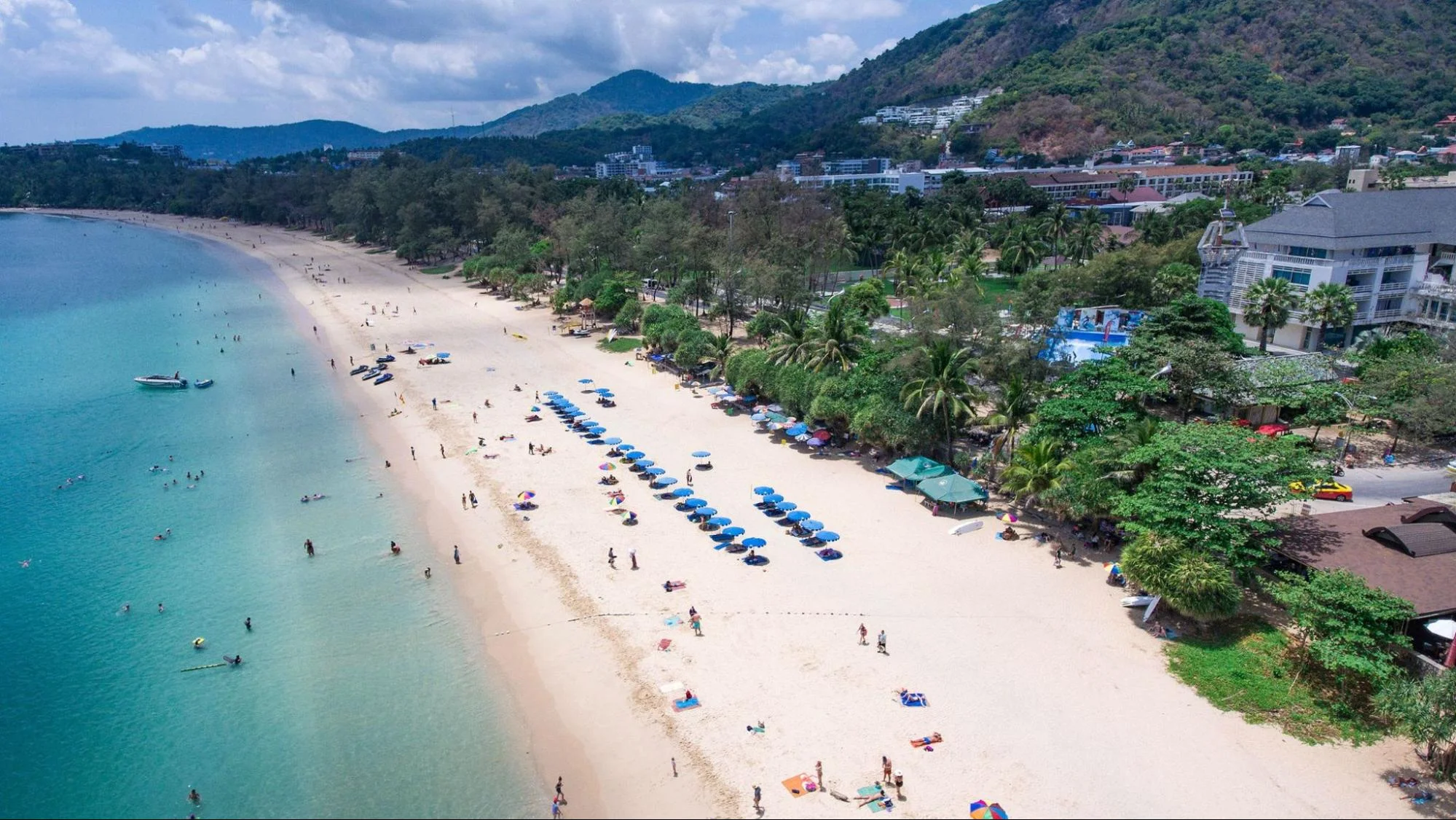 Long stretch of sandy tropical beach and blue sea