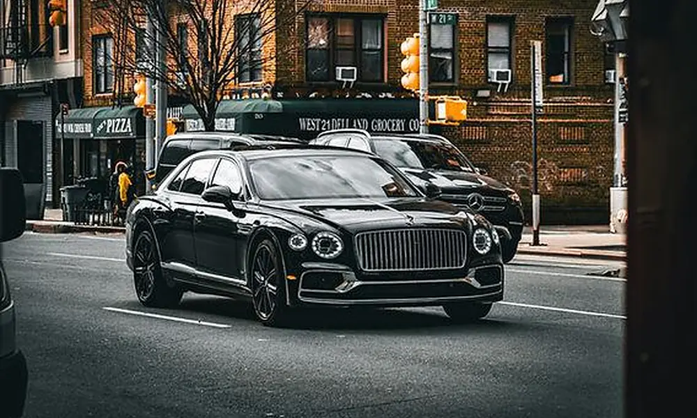 Black sedan navigating urban traffic, illustrating everyday usage for luxury vehicles in Manhattan-Most Luxurious Cars in New York