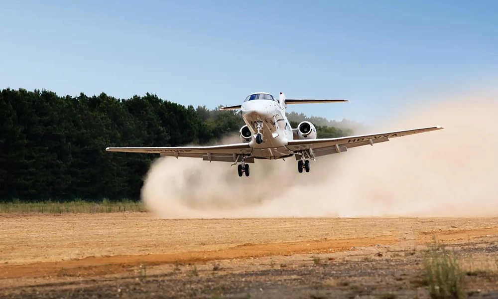 Pilatus PC-24 light jet taking off from an unpaved dirt runway with dust clouds kicking up-Best Private Jets in New York