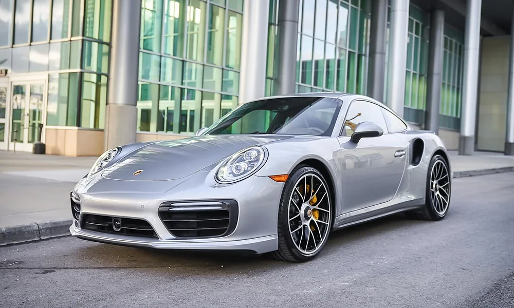 Silver Porsche 911 Turbo S sports car parked outside a modern building-Most Luxurious Cars in New York