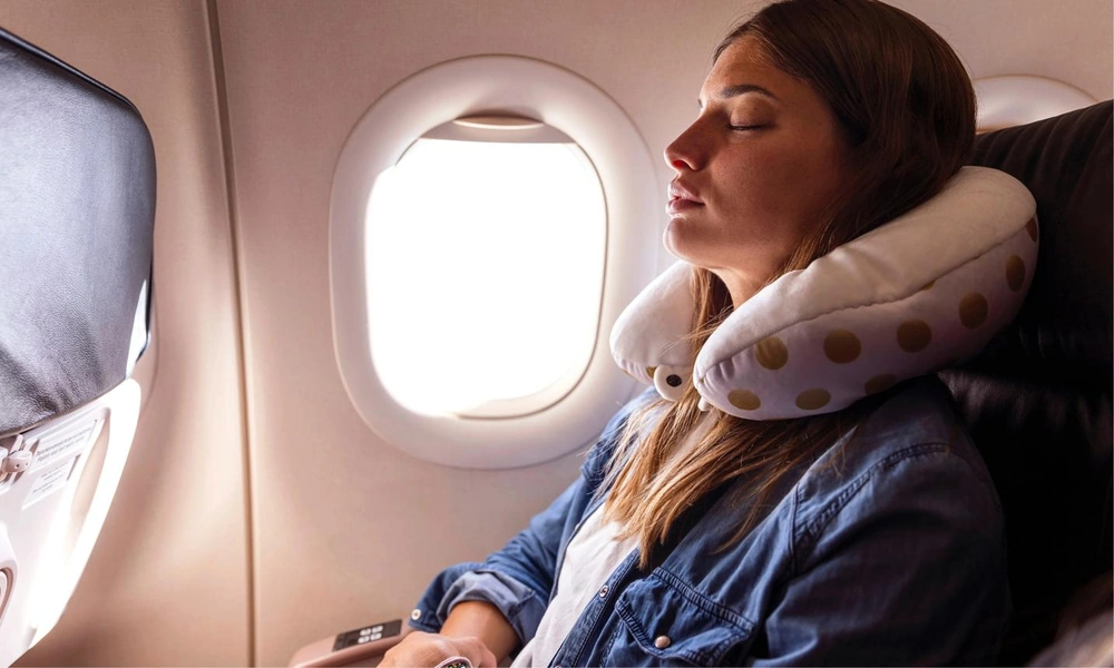 Passenger resting with a supportive travel neck pillow.